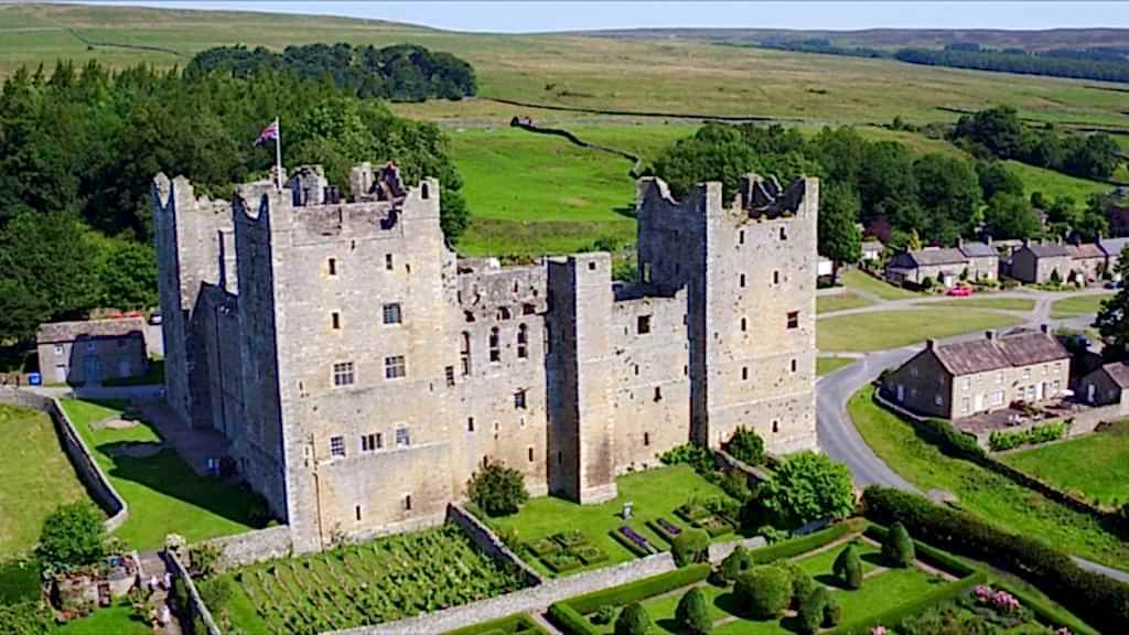 The image shows Bolton Castle which is a 14th-century castle located in Wensleydale, Yorkshire, England. It has never been sold and is still in the ownership the Scrope family. Its gardens are perfect for a relaxed day out with the family.