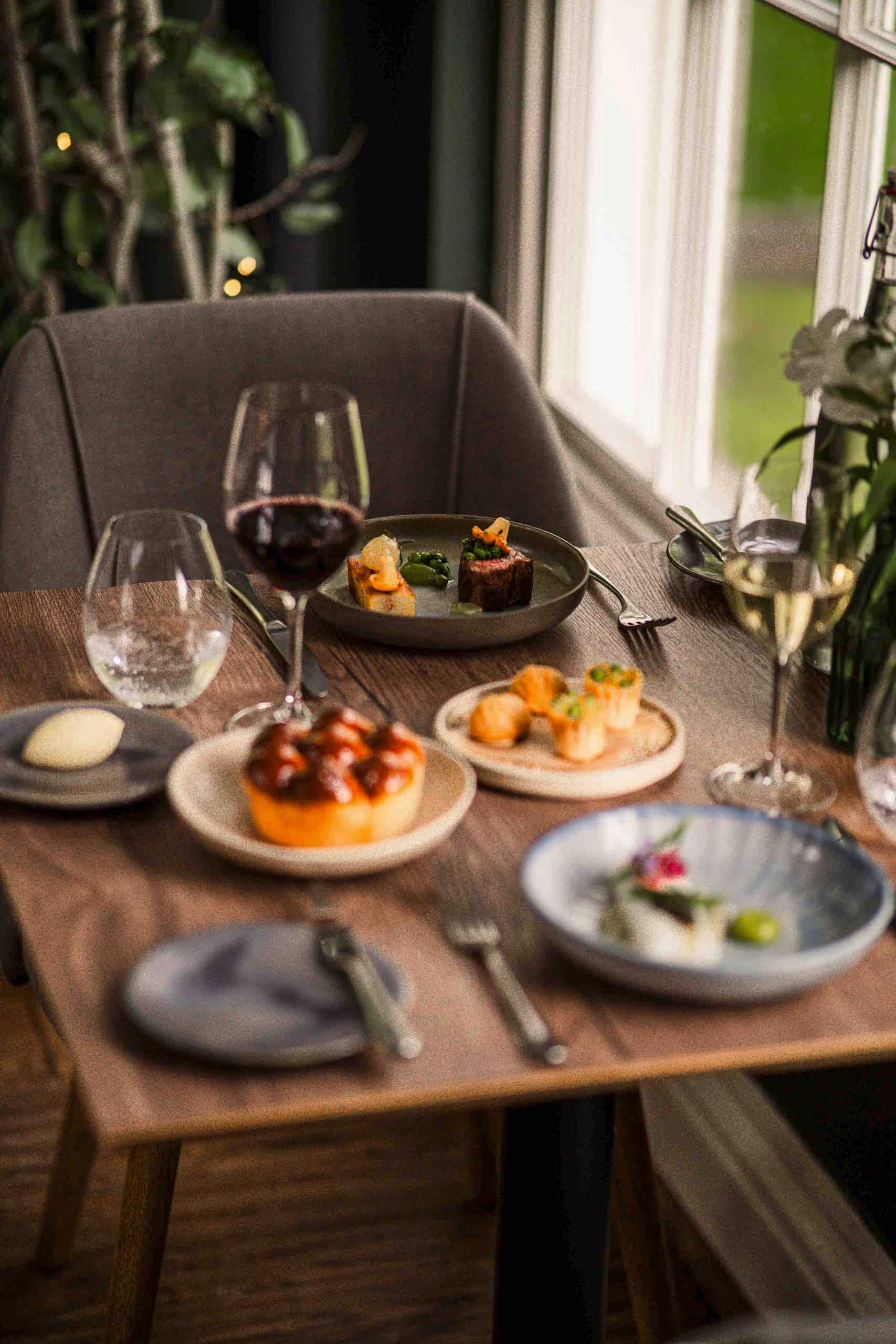 The image shows a table in the Orangery set up for dinner at Yorebridge House Hotel in North Yorkshire.