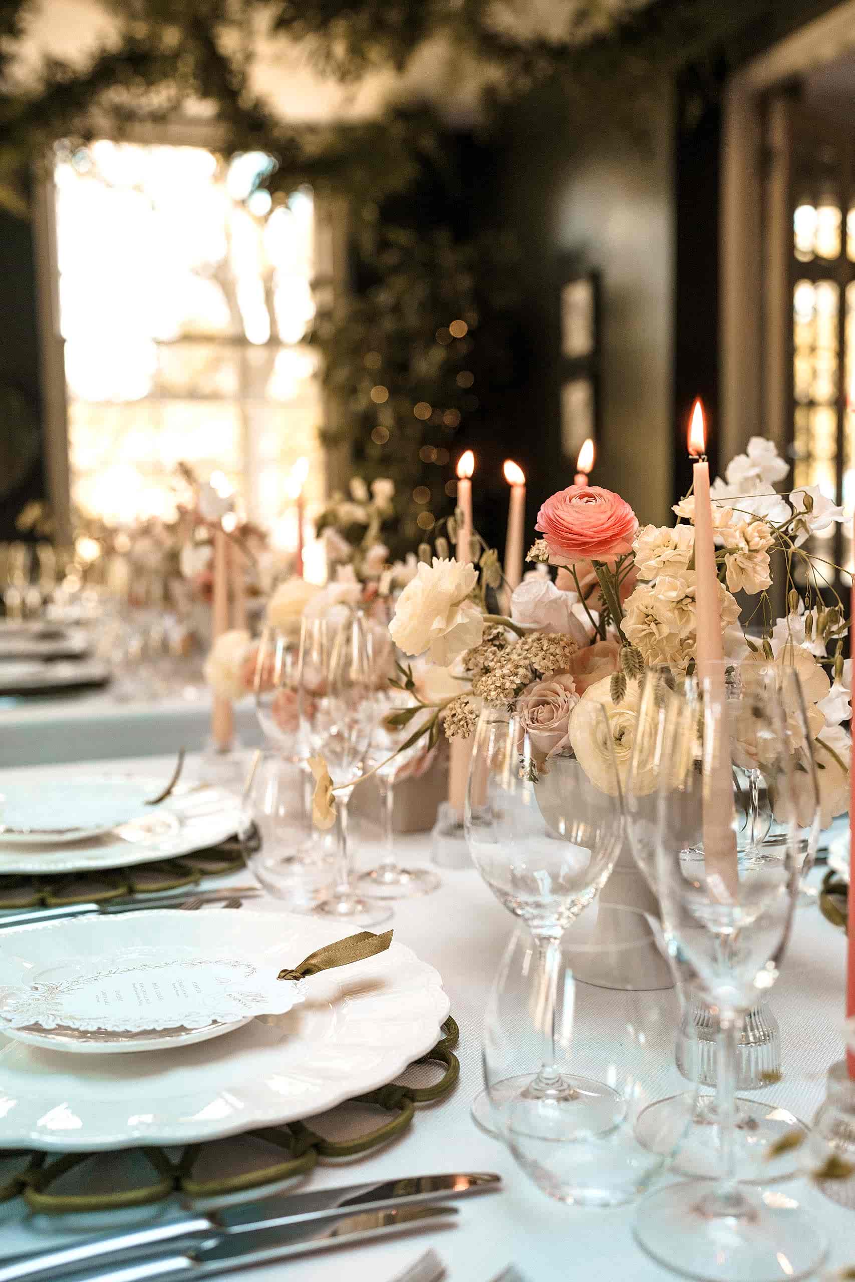 The image shows a picture of a wedding breakfast set up in the Orangery at Yorebridge House with pastel floral arrangements all down the table.