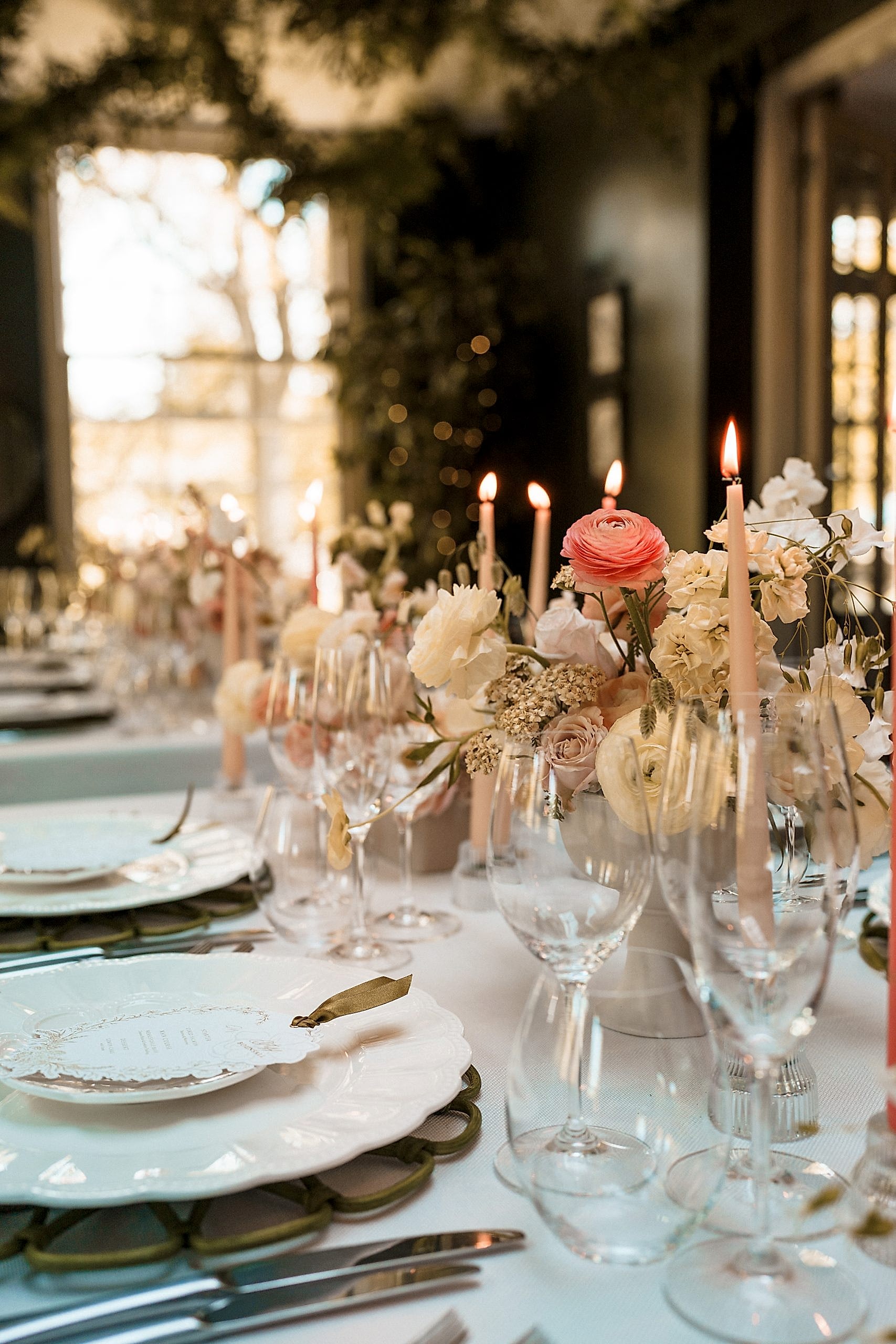 The image shows a picture of a wedding breakfast set up in the Orangery at Yorebridge House with pastel floral arrangements all down the table.