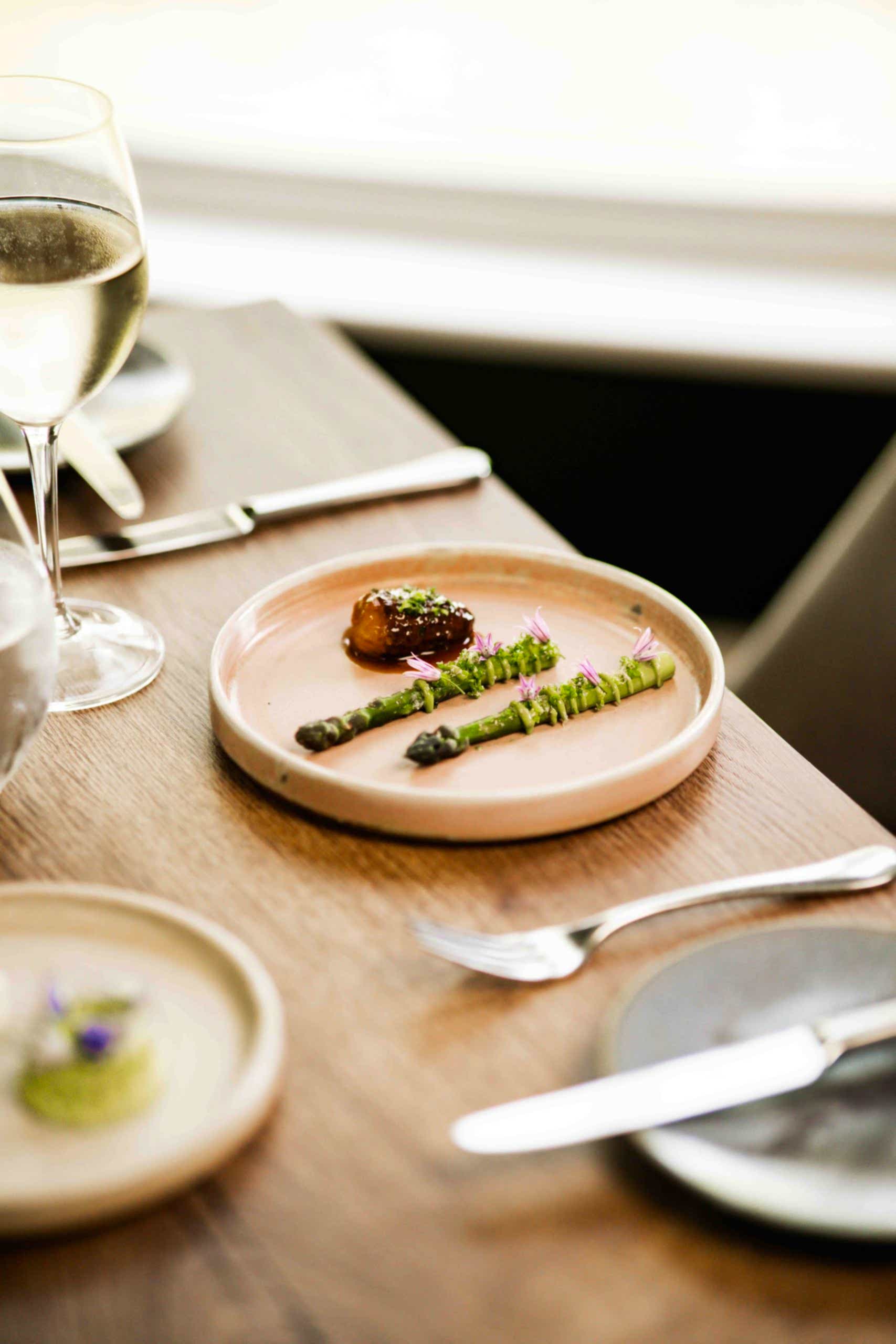 The image shows asparagus, morel and parsley from their fine dining seven course tasting menu. Their restaurant was awarded 3AA Rosette for the 10th consecutive year as well as being named on the Michelin guide. The hotel is in the in Bainbridge, North Yorkshire. The menu is finished with a wine pairing so ensure the food is complemented well.