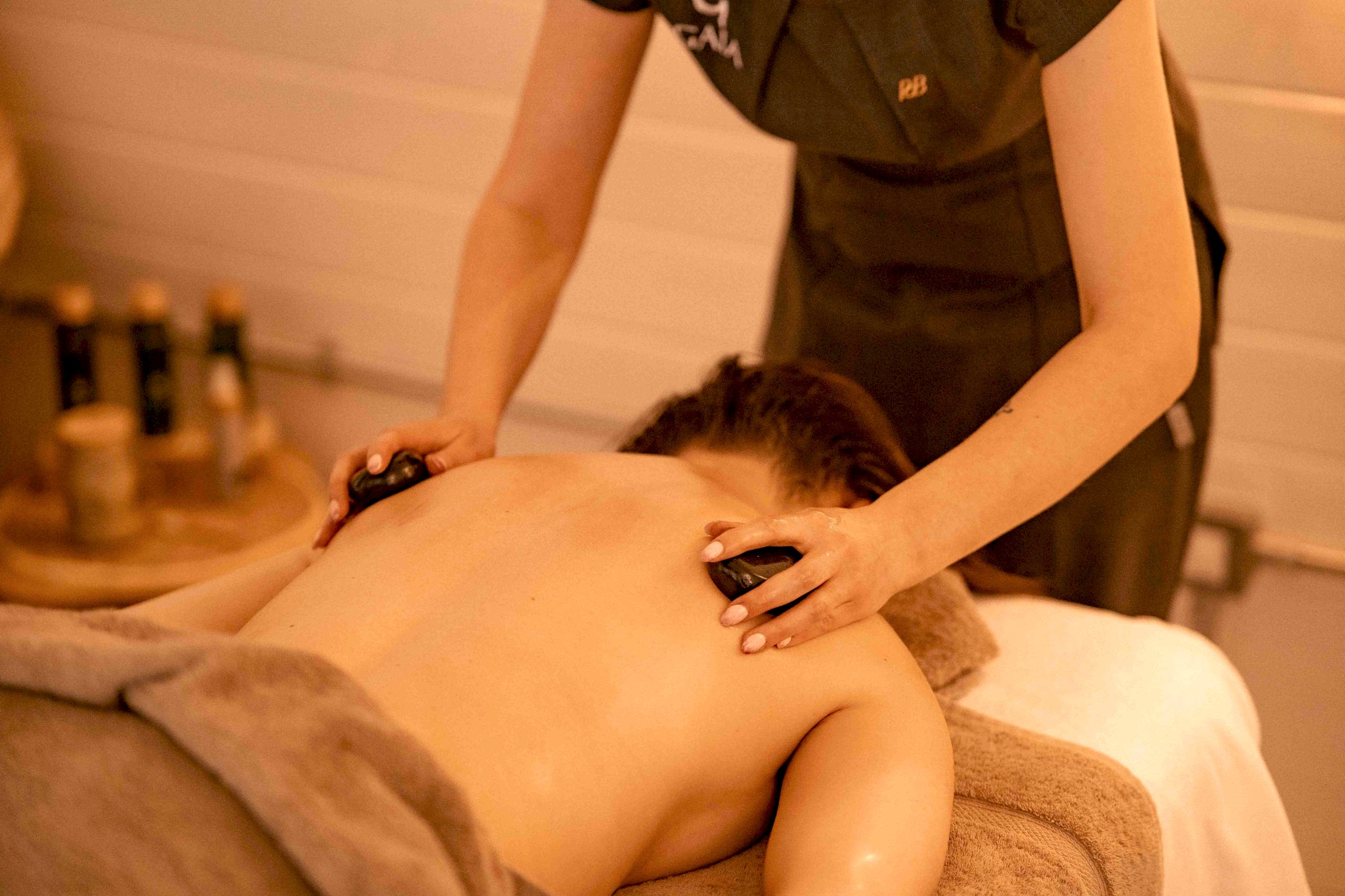 The image shows the treatment room at Ure River Retreat spa facilities at Yorebridge House Hotel in North Yorkshire. The customer is getting a massage from the spa therapist. The Ure River Retreat is nestled in the Yorkshire Dales and sits beside the River Ure.