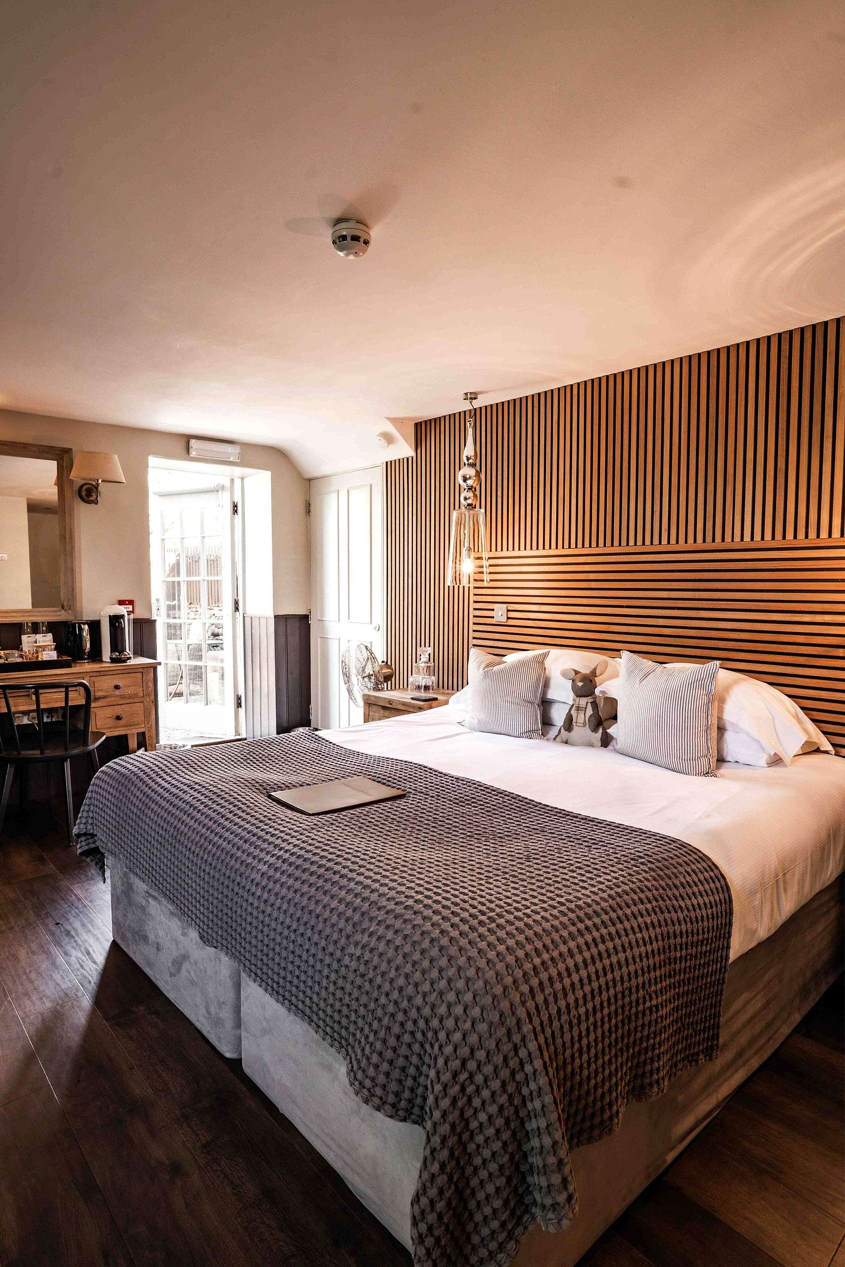 The image shows Rangali hot tub suite at Yorebridge House Hotel in Bainbridge, North Yorkshire. Rangali has a private terrace and super king size bed.