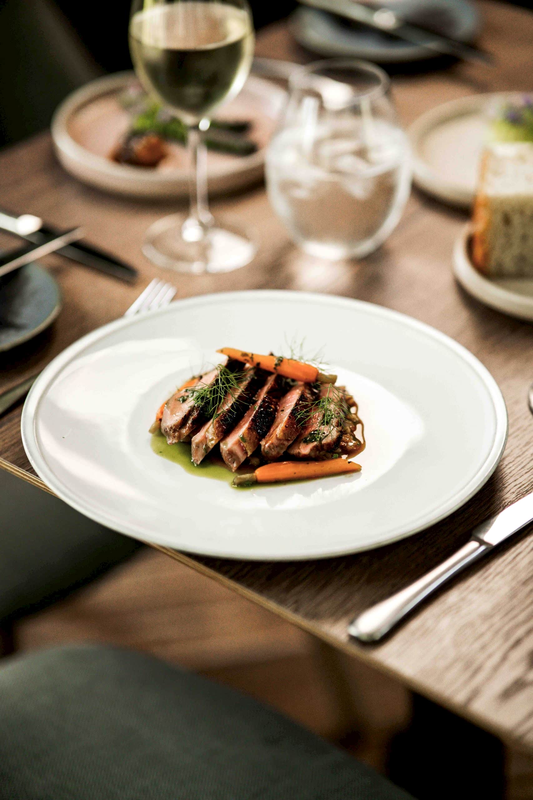 The image shows the duck, lentil and heritage carrot dish in the Orangery at Yorebridge House. Their fine dining experience was awarded 3AA Rosette for the 10th consecutive year as well as being named on the Michelin guide. The restaurant is in the Yorkshire Dales at Yorebridge House Hotel in Bainbridge. The menu is finished with a wine pairing so ensure the food is complemented well.